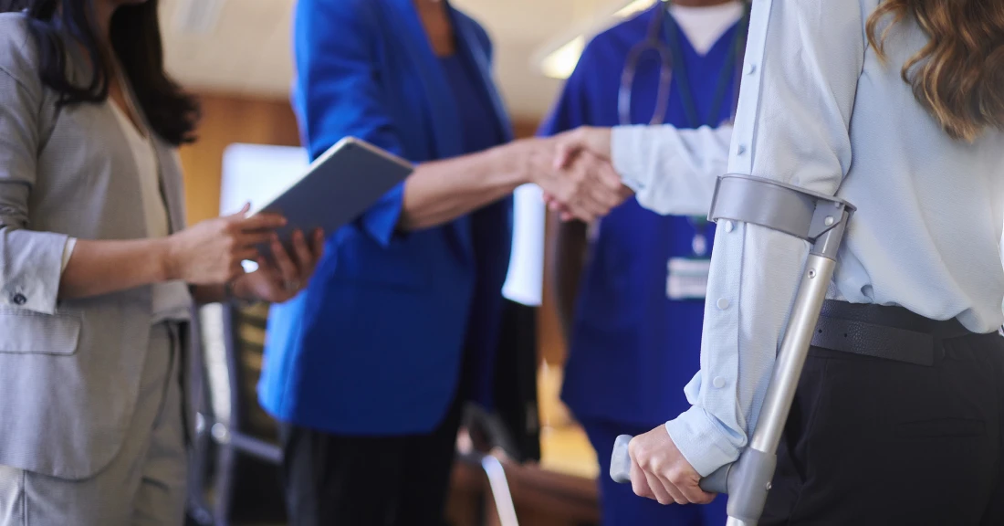 Diverse team discussing with tablets and crutches