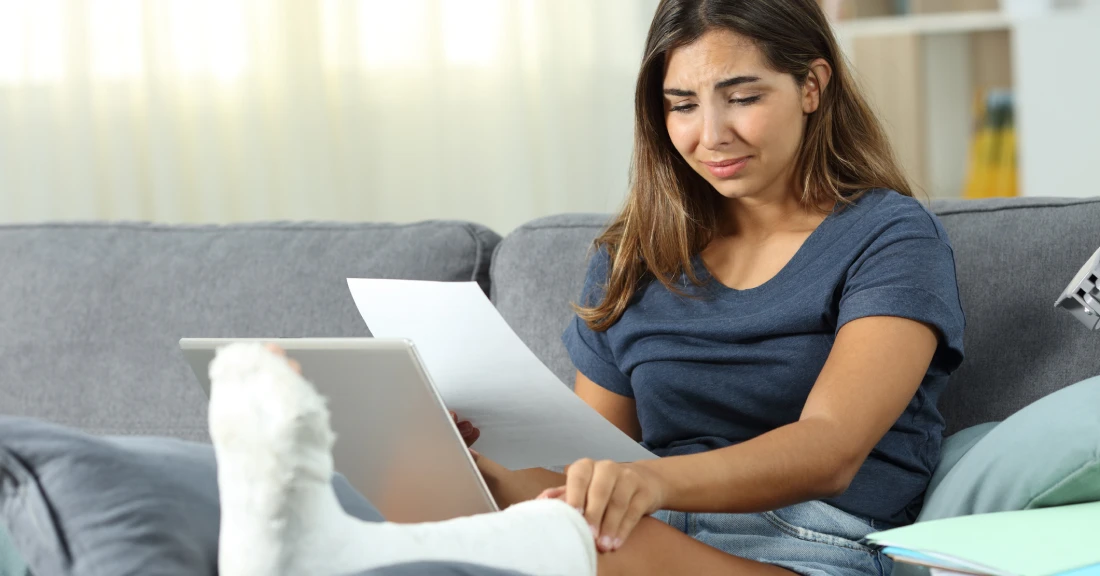 Female with bandaged foot holding paper